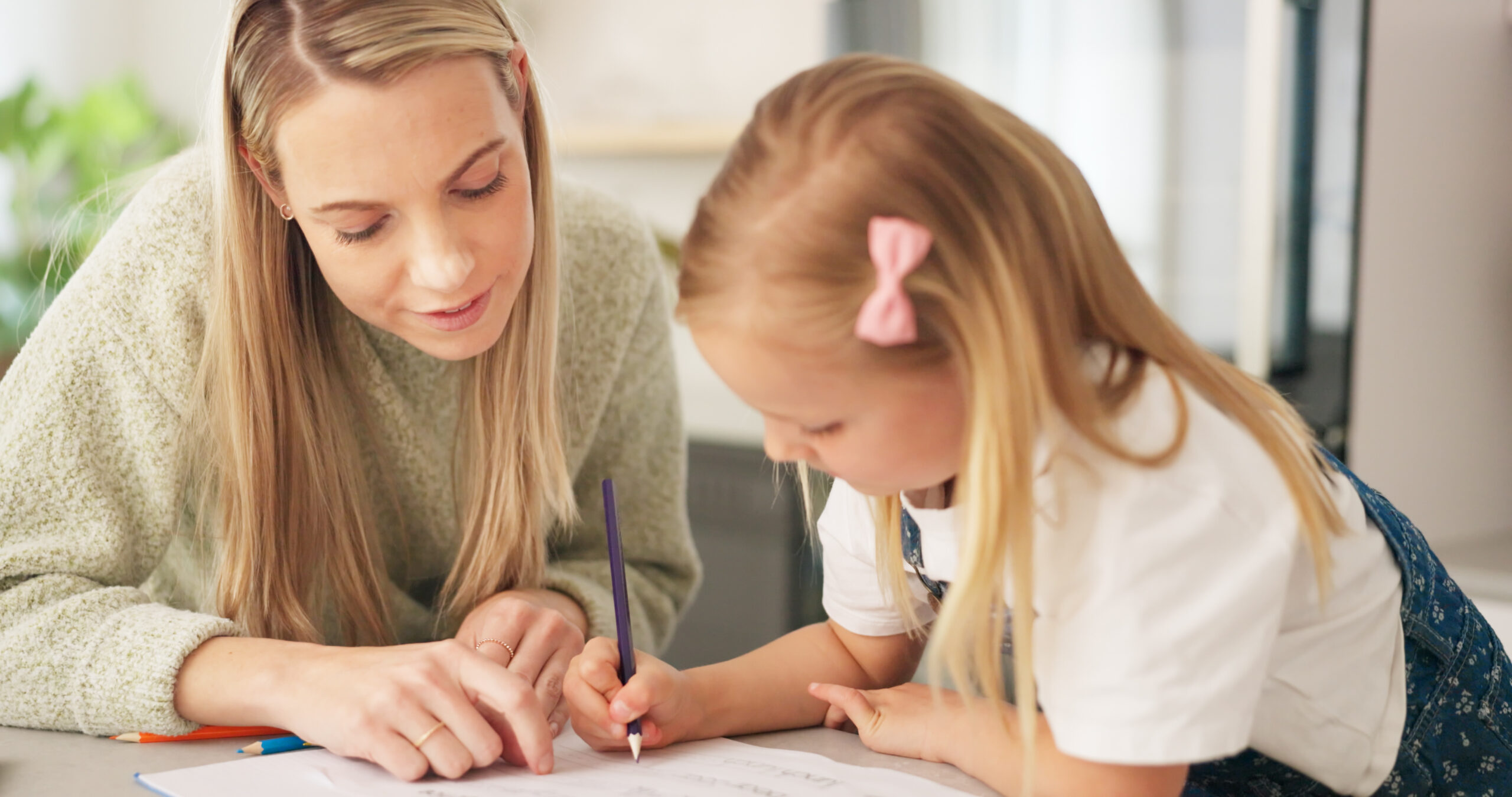 Education, mother and learning child writing or drawing for kindergarten school homework or project.